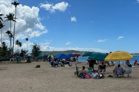 a group of people sitting at a beach