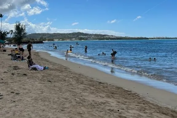 a group of people sitting at a beach