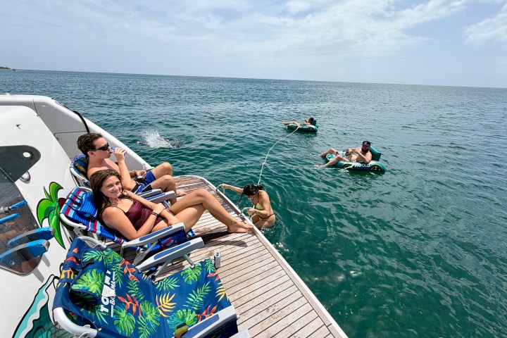People relaxing on a boat deck and floating in the sea on a sunny day.